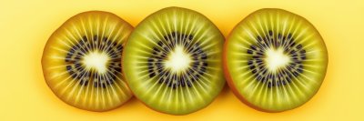 Freshly sliced kiwi fruit arranged on a bright yellow background showcasing vibrant colors and unique textures