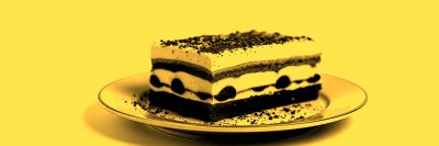 D e l i c i o u s   l a y e r e d   d e s s e r t   s e r v e d   o n   a   w h i t e   p l a t e ,   s h o w c a s i n g   r i c h   f l a v o r s   a n d   t e x t u r e s