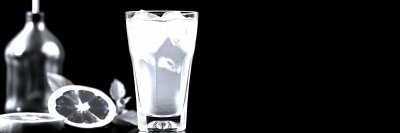 B r i g h t   p i n k   b e v e r a g e   s e r v e d   i n   a   g l a s s   w i t h   i c e   a l o n g s i d e   f r e s h   f r u i t   o n   a   d a r k   b a c k g r o u n d