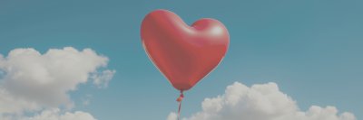 A   v i b r a n t   r e d   h e a r t - s h a p e d   b a l l o o n   a s c e n d s   a g a i n s t   a   b a c k d r o p   o f   a   c l e a r   b l u e   s k y   d o t t e d   w i t h   s o f t ,   w h i t e   c u m u l u s   c l o u d s