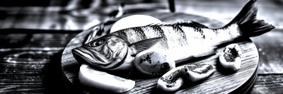 A   f r e s h   f i s h   o n   a   w o o d e n   b o a r d   w i t h   l e m o n   s l i c e s   a n d   a p r i c o t s