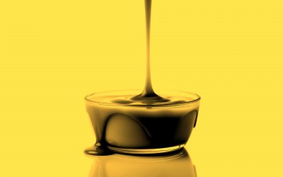 C a r a m e l   i s   b e i n g   p o u r e d   i n t o   a   g l a s s   b o w l   a g a i n s t   a   w h i t e   b a c k g r o u n d